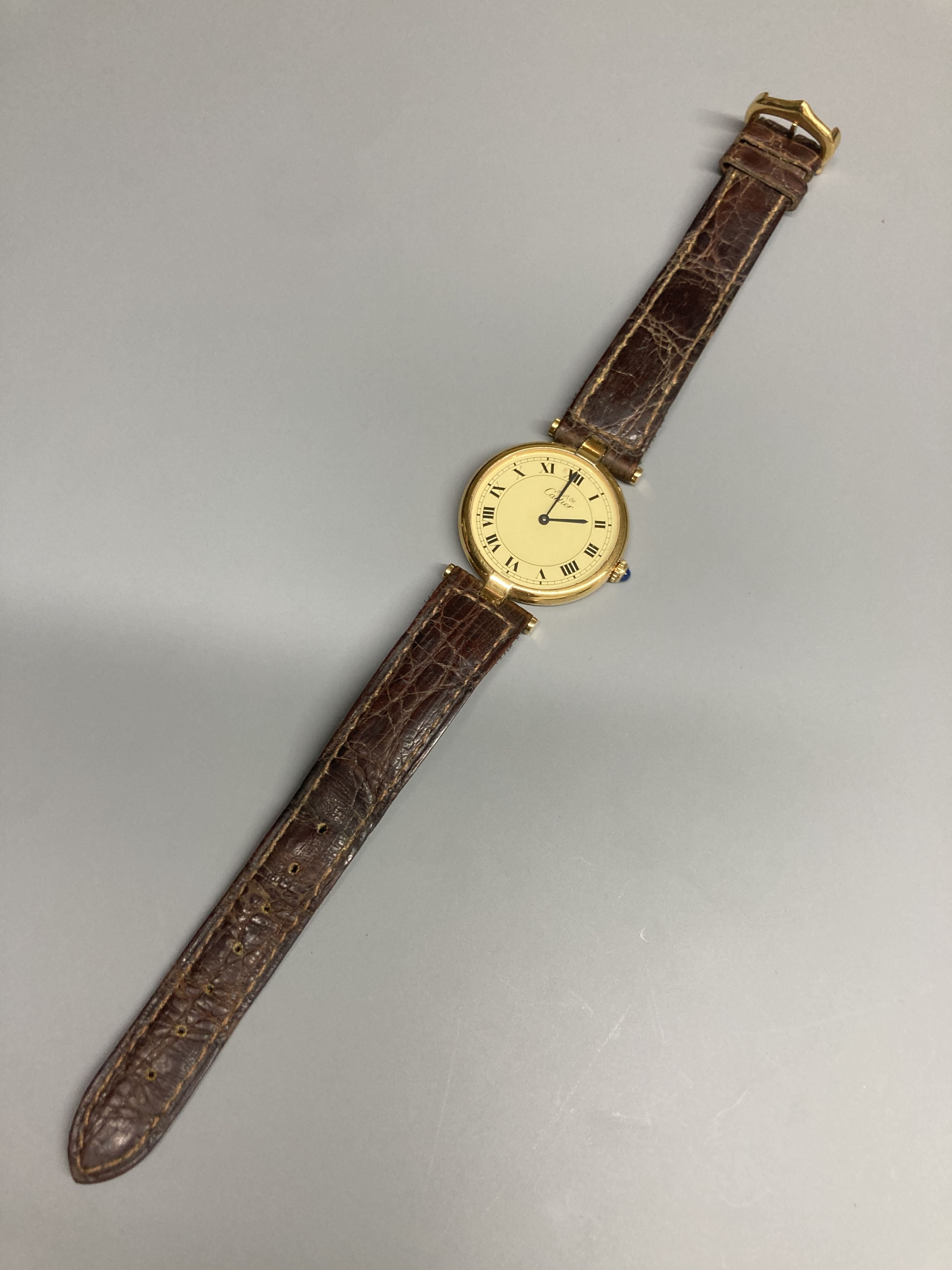 A modern Cartier Vermeil gilt 925 quartz wrist watch, with circular Roman dial and cabochon set crown, on a Cartier leather strap, case diameter 30mm ex. crown.